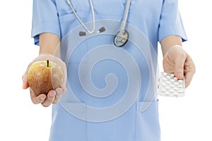 Nurse or doctor showing a pack of tablets and an apple