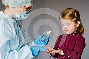 Nurse or doctor use Hand sanitizer alcohol gel rub clean hands child, hygiene prevention of coronavirus virus outbreak. Child