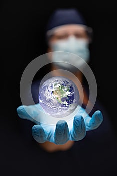 Nurse or Doctor Wearing Face Mask and Surgical Gloves with Palm Under the Floating Planet Earth
