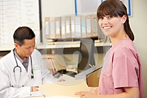 Nurse With Doctor Working At Nurses Station