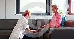 Nurse doing hand massage to her senior patient