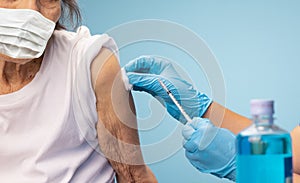 Nurse doing vaccine injection to senior woman