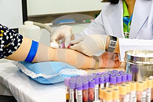 Nurse drawing blood sample from arm patient for blood test