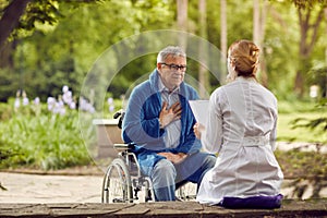 Nurse with elderly man in wheelchair who don`t feel good