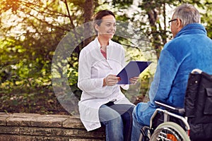 Nurse with elderly man disabled in wheelchair