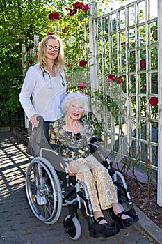 Nurse and Elderly on Wheelchair Smiling at Camera