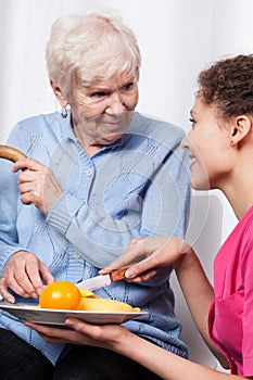 Nurse and elderly woman eating fruits