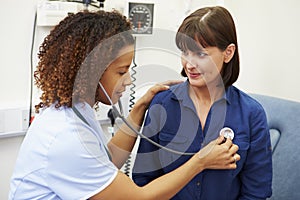 Nurse Examining Female Patient In Hospital