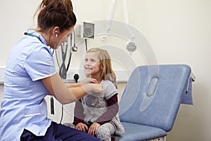 Nurse Examining Young Girl In Hospital