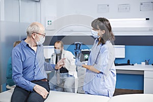 Nurse explains radiography to old man photo