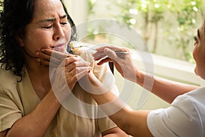 Nurse giving apple to adult female patient