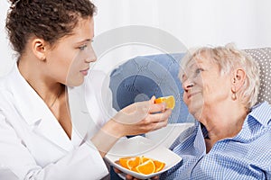 Nurse feeding an elderly woman