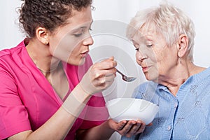 Nurse feeding an older lady