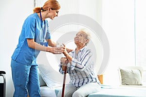 Nurse giving glass of water to elderly woman. Medical assistance