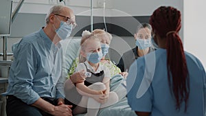 Nurse giving recovery advice to patient and visitors with face mask