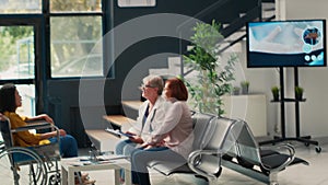 Nurse giving support to patient with impairment in wheelchair