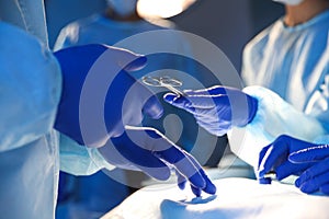 Nurse giving tool to doctor in surgery room