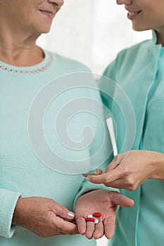 Nurse giving woman medicament photo