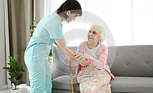 Nurse Hands Cane To Elderly Woman, Helping Her Move Around Room