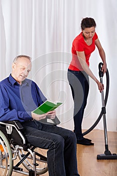 Nurse helping disabled with cleaning