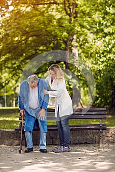 Nurse helping elderly disabled man