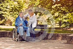 Nurse helping elderly man on wheelchair