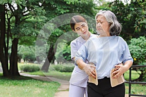 Nurse helping elderly people wear back brace for back muscles