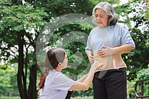 Nurse helping elderly people wear back brace for back muscles