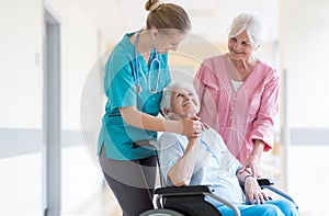 Nurse helping elderly woman in wheelchair