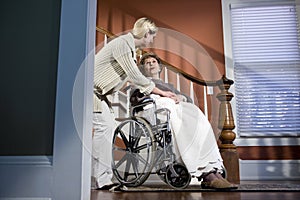 Zdravotní sestra pomáháme starší žena v invalidní vozík na 