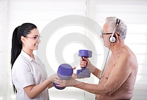 Nurse helping old man with dumbbells