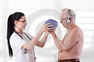 Nurse helping old man with dumbbells