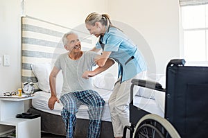 Nurse helping old patient get up