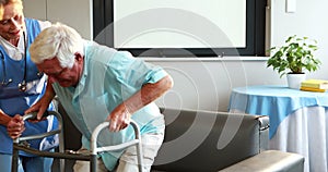 Nurse helping retired man with walker