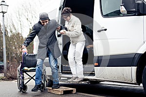 Nurse Helping Senior Man Exit A Van