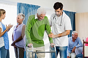 Nurse helping senior with walking aid