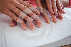 Nurse helping senior woman with braille