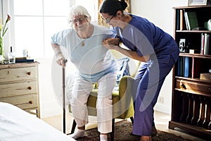 Nurse helping senior woman to stand photo