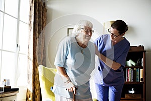 Nurse helping senior woman to stand photo