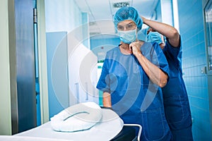 Nurse helping a surgeon in tying surgical mask