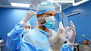 Nurse helping a surgeon in tying surgical mask