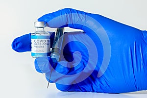 Nurse holding a COVID-19 vaccine and an injection needle