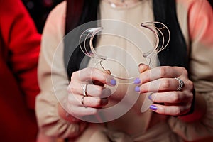 Nurse holding a dental retractor in her hands. Dental Cheek Retractor close-up in hands. Lip Retractors.