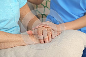 Nurse holding elderly woman`s hands. Assisting senior people