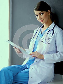 Nurse holding folder and taking notes - sitting