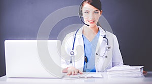Nurse holding folder and taking notes - sitting on gray background