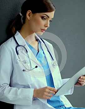 Nurse holding folder and taking notes - sitting on grey background