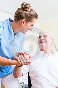 Nurse holding hand of senior man in rest home