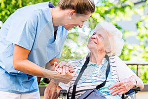 Nurse holding hand of senior woman in pension home