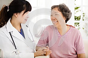 Nurse holding hand of senior woman in rest home